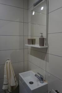 een witte badkamer met een wastafel en een spiegel bij Apartments with a parking space Senj - 16747 in Senj