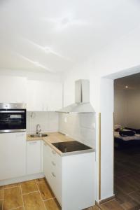 een witte keuken met een wastafel en een fornuis bij Apartments with a parking space Senj - 16747 in Senj