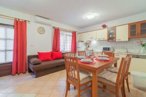 a kitchen and living room with a table and chairs at Apartments with a parking space Vir - 16768 in Vir