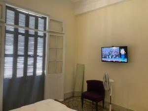 Dar Joury في طنجة: غرفة نوم مع سرير وتلفزيون على الحائط