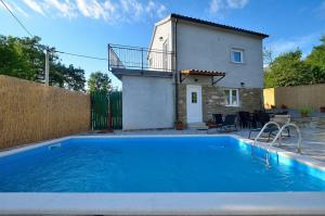 eine Villa mit einem Pool vor einem Haus in der Unterkunft Holiday house with a swimming pool Sovinjsko Polje, Central Istria - Sredisnja Istra - 16806 in Buzet
