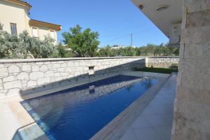 a swimming pool with a stone retaining wall and anergynergynergynergyploadpload at Nalyakonak in Alacati