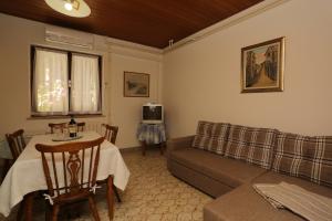 a living room with a couch and a table at Apartments with a parking space Supetar, Brac - 16807 in Supetar