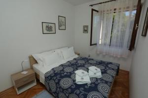 - une chambre avec un lit avec deux chaussures dans l'établissement Apartments with a parking space Supetar, Brac - 16807, à Supetar