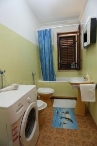 ein Badezimmer mit einer Waschmaschine und einem WC in der Unterkunft Apartments with a parking space Supetar, Brac - 16807 in Supetar