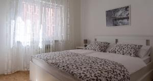 a bedroom with a bed and a window with white curtains at Apartments with WiFi Vinkovci, Slavonija - 16805 in Vinkovci