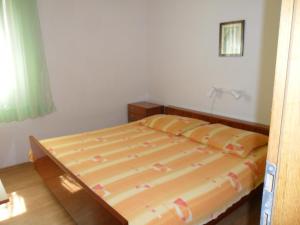 a bedroom with a large bed with a wooden frame at Apartments by the sea Sevid, Trogir - 16855 in Marina