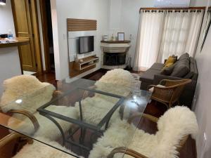 a living room with a glass table and a couch at Apto próximo aos pontos turísticos e restaurantes in Gramado