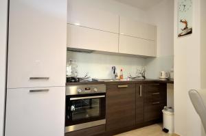a kitchen with white cabinets and an oven at Apartment Tribunj 16884b in Tribunj