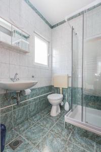 uma casa de banho com um WC, um lavatório e um chuveiro em Apartments with a parking space Kastel Stafilic, Kastela - 16811 em Kaštela