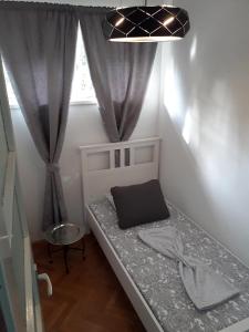 uma pequena cama num quarto com uma janela em Apartments with WiFi Split - 16911 em Split