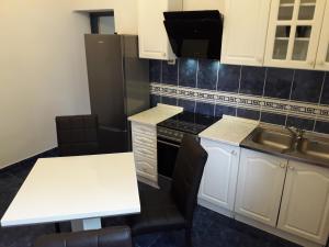 uma cozinha com armários brancos e uma mesa e cadeiras brancas em Apartments with WiFi Split - 16911 em Split