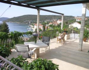 a patio with a table and chairs and a view of the water at Seaside holiday house Drvenik Veliki, Drvenik - 16937 in Drvenik Veli