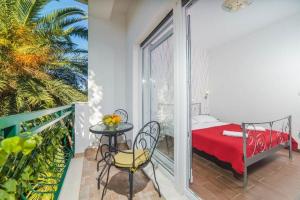 a room with a bed and a table and a balcony at Apartments by the sea Podstrana, Split - 16829 in Podstrana