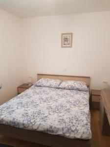 1 dormitorio con 1 cama con edredón azul y blanco en Apartment Novi Vinodolski 16998b, en Novi Vinodolski