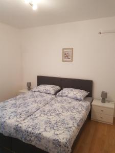 1 dormitorio con 1 cama y 2 mesitas de noche en Apartment Novi Vinodolski 16998b, en Novi Vinodolski