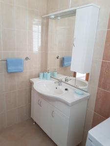 y baño con lavabo blanco y espejo. en Apartment Novi Vinodolski 16998b, en Novi Vinodolski