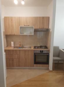 a kitchen with wooden cabinets and a sink and a stove at Studio Novi Vinodolski 16998a in Novi Vinodolski