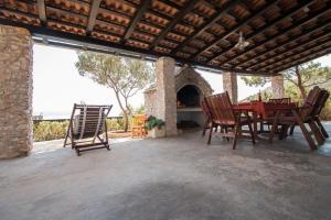 a patio with a table and chairs and a fireplace at Secluded fisherman's cottage Cove Spiljice, Brac - 17031 in Selca