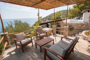 a patio with chairs and a table and a view of the ocean at Secluded fisherman's cottage Cove Spiljice, Brac - 17031 in Selca