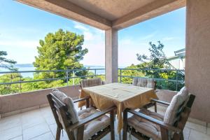 a dining room with a table and chairs on a balcony at Apartments with a parking space Brela, Makarska - 16596 in Brela