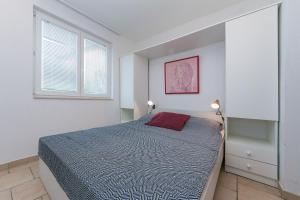 biała sypialnia z łóżkiem i oknem w obiekcie Apartments with a parking space Brela, Makarska - 16596 w Breli
