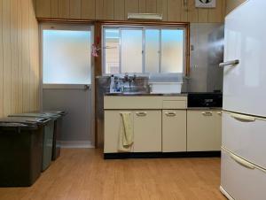EBISUYA في Susami: مطبخ مع ثلاجة بيضاء ومغسلة