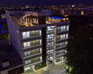 um edifício alto com luzes acesas numa cidade à noite em OneBR w Balcony or Studio in Playa del Carmen w Balcony, BBQ, Pool Infinite, AC, TV Smart, 150mb em Playa del Carmen