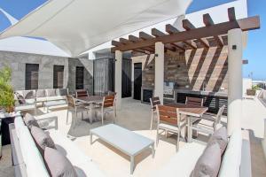 patio ze stołami i krzesłami oraz kominkiem w obiekcie OneBR w Balcony or Studio in Playa del Carmen w Balcony, BBQ, Pool Infinite, AC, TV Smart, 150mb w mieście Playa del Carmen