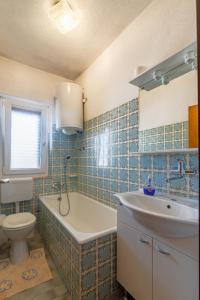 a bathroom with a tub and a toilet and a sink at Apartments by the sea Povlja, Brac - 16792 in Povlja