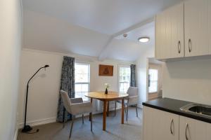 a kitchen and dining room with a table and chairs at The Old Oak Boutique Hotel in Mangonui