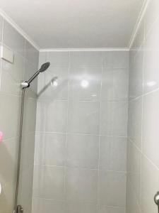 a shower with a shower head in a bathroom at One Spatial Iloilo Two Bedroom Condominium Unit with Pool and Gym in Iloilo City