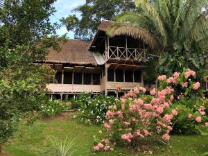 a house with a bunch of flowers in front of it at Sotupa Eco Lodge in Puerto Maldonado