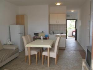 a kitchen and dining room with a table and chairs at Apartments with parking space Barbat, Rab - 16816 in Rab