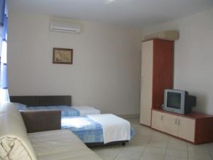 a hotel room with two beds and a tv at Apartments with parking space Barbat, Rab - 16816 in Rab