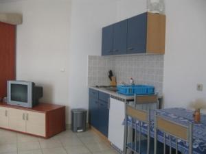 a kitchen with blue cabinets and a tv on a counter at Apartments with parking space Barbat, Rab - 16816 in Rab +15 photos