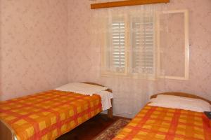 Cette chambre comprend 2 lits et une fenêtre. dans l'établissement Apartments by the sea Prizba, Korcula - 16900, à Prižba