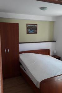 una camera con un letto e una foto appesa al muro di Apartments with WiFi Olib - 16674 a Olib (Ulbo)