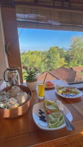 a table with two plates of food and a window at Raditya House in Ubud