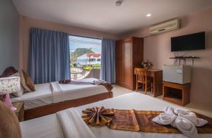 Habitación de hotel con 2 camas y ventana en Mukanda Residence, en Ao Nang Beach