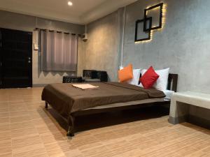 a bedroom with a bed with red and orange pillows at The Loft @Chiangrai in Ban Du