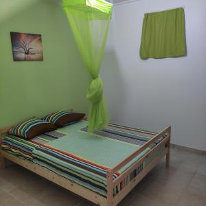 a bed in a room with a mosquito net at La Jandyra in Gros-Morne