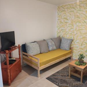 a living room with a yellow couch and a tv at La Jandyra in Gros-Morne