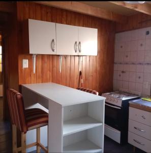 een keuken met een witte tafel en 2 stoelen bij CABAÑA LOS MORROS in Ushuaia