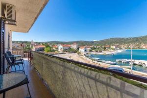 a balcony with a view of a harbor and the water at Apartments by the sea Vinisce, Trogir - 16860 in Vinišće