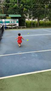 een klein meisje dat tennist op een tennisbaan bij Khách sạn Phương Dung in Cửa Lô