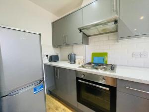 a kitchen with stainless steel appliances and a refrigerator at Lovely 2 bedroom serviced apartment in London in London