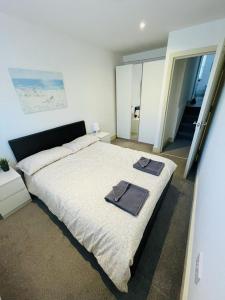 a bedroom with a large bed with towels on it at Lovely 2 bedroom serviced apartment in London in London