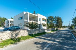 une voiture bleue garée devant une maison blanche dans l'établissement Apartments with a parking space Vir - 18539, à Vir