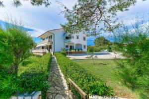 dom z kamienną ścieżką przed nim w obiekcie Apartments by the sea Vir - 18590 w mieście Vir